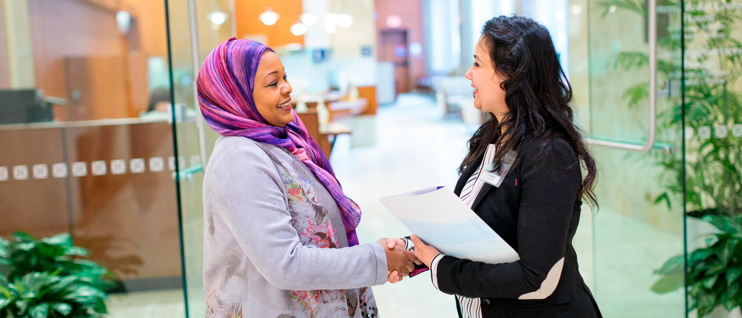 International patient arriving at Mayo Clinic greeted by a staff member in the clinic lobby.